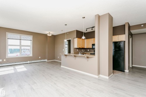 Open concept living area with light wood-finish flooring - 1-402 4245 139 Avenue, Edmonton, AB - Indoor