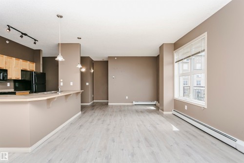 Open-concept living space with light wood-finish flooring - 1-402 4245 139 Avenue, Edmonton, AB - Indoor Photo Showing Kitchen