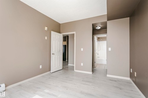 Spacious room featuring light wood-finish flooring, neutral wall paint, and white trim - 1-402 4245 139 Avenue, Edmonton, AB - Indoor Photo Showing Other Room
