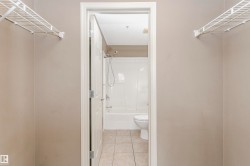 Bathroom featuring a white tub/shower combination, toilet, and tiled flooring - 