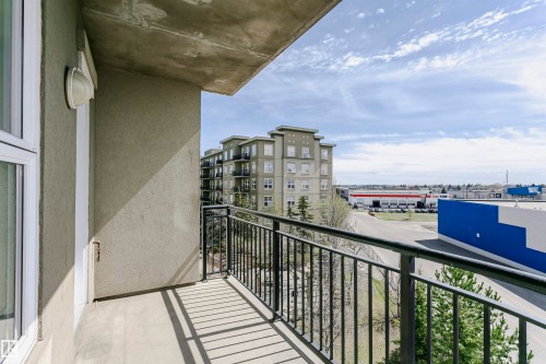 Balcony with concrete flooring and black metal railings, offering an urban outlook - 1-402 4245 139 Avenue, Edmonton, AB - Outdoor With Balcony With Exterior