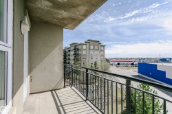 Balcony with concrete flooring and black metal railings, offering an urban outlook - 