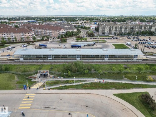 Modern transit station featuring a metal roof and extensive glazing, positioned alongside railway tracks - 1-402 4245 139 Avenue, Edmonton, AB - Outdoor With View