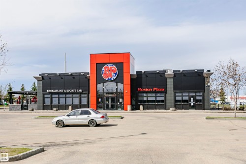 Commercial building featuring a modern facade with black paneling and red accents - 1-402 4245 139 Avenue, Edmonton, AB - Outdoor
