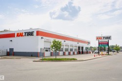 Commercial building with a white and orange exterior and multiple service bays - 
