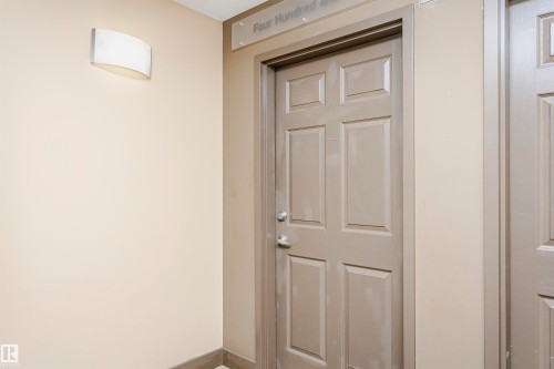 Entryway featuring a six-panel door with a brushed nickel doorknob and deadbolt - 1-402 4245 139 Avenue, Edmonton, AB - Indoor Photo Showing Other Room