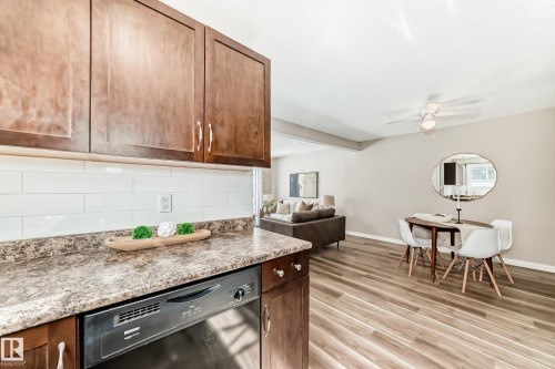 The kitchen features wood cabinetry, a subway tile backsplash, and a dishwasher - 10327 150 Street, Edmonton, AB - Indoor Photo Showing Kitchen