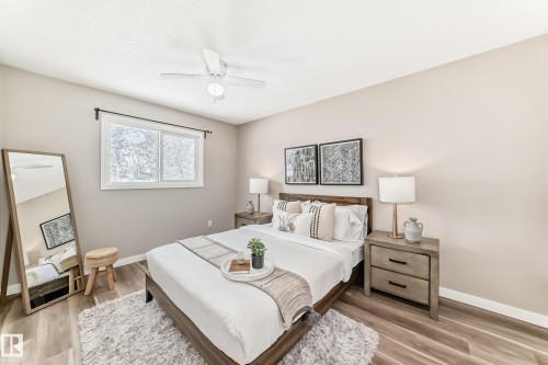 This room features light-toned walls, a window with a dark curtain rod, and a ceiling fan - 10327 150 Street, Edmonton, AB - Indoor Photo Showing Bedroom