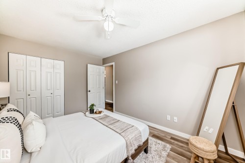 Bedroom with light-toned walls, wood-style flooring, and a ceiling fan - 10327 150 Street, Edmonton, AB - Indoor Photo Showing Bedroom