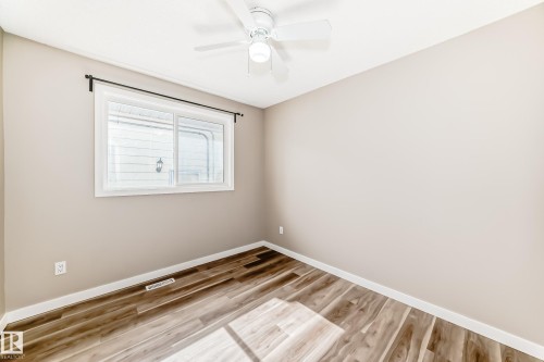 The room features warm-toned flooring, a window providing natural light, and a ceiling fan - 10327 150 Street, Edmonton, AB - Indoor Photo Showing Other Room