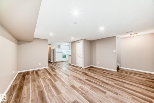 The property features wood-look flooring, light-colored walls, and recessed lighting throughout - 10327 150 Street, Edmonton, AB - Indoor Photo Showing Other Room