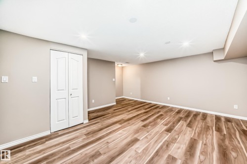 Spacious room featuring wood-look flooring, light-colored walls, and recessed lighting - 10327 150 Street, Edmonton, AB - Indoor