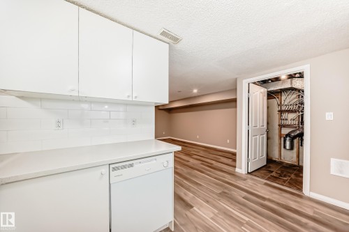 The property features white cabinetry, a white subway tile backsplash, and a white dishwasher - 10327 150 Street, Edmonton, AB - Indoor