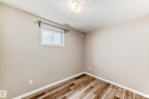 This room features wood-look flooring, a window, and neutral-toned walls - 10327 150 Street, Edmonton, AB - Indoor Photo Showing Other Room