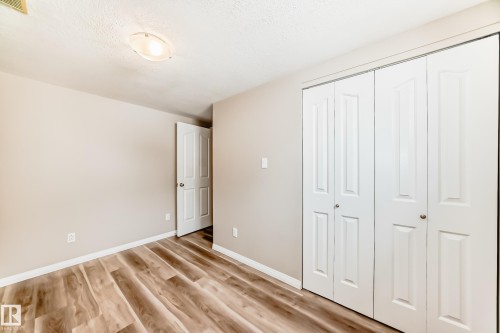 This room features light-toned wood-style flooring, a light-colored wall, and a white ceiling - 10327 150 Street, Edmonton, AB - Indoor Photo Showing Other Room