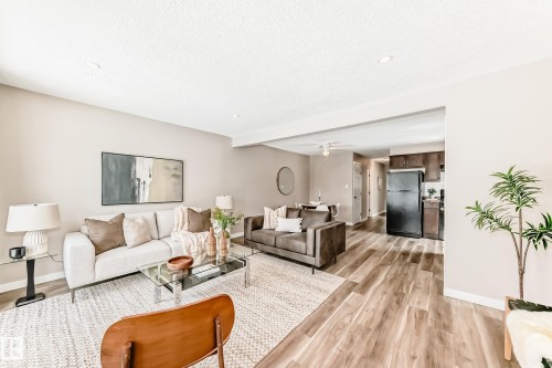 This inviting living space features warm-toned walls, recessed lighting, and wood-look flooring - 10327 150 Street, Edmonton, AB - Indoor Photo Showing Living Room