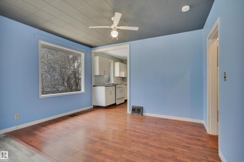 Spacious interior with wood-finish flooring, a large picture window, and a ceiling fan - 4907 48 Avenue, Leduc, AB - Indoor