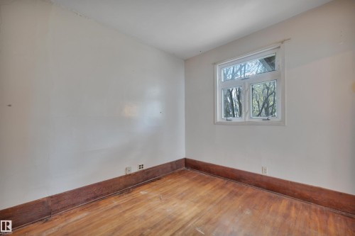 Room featuring wood-finish flooring and white walls - 4907 48 Avenue, Leduc, AB - Indoor Photo Showing Other Room