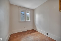 Room featuring wood-finish flooring, light-toned walls, and a double window with white trim - 