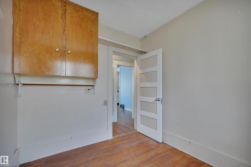 Room featuring wood-finish flooring, light neutral wall paint, and white trim - 4907 48 Avenue, Leduc, AB - Indoor Photo Showing Other Room