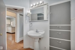 Pedestal sink with chrome faucet, wall-mounted mirror, and vanity lighting - 
