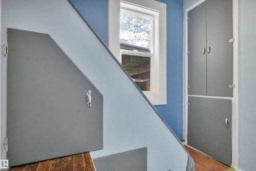 Under-stair storage compartments with gray paneling and chrome hardware - 4907 48 Avenue, Leduc, AB - Indoor Photo Showing Other Room
