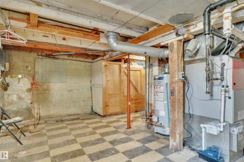 Utility room featuring a patterned tile floor, exposed ceiling joists, wood paneling, and visible mechanical systems - 4907 48 Avenue, Leduc, AB - Indoor Photo Showing Basement