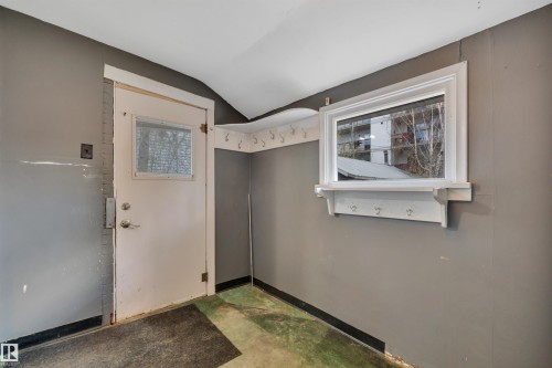Enclosed entryway featuring a white framed door with a window insert, a separate horizontal window with a white sill, and wall-mounted coat hooks - 4907 48 Avenue, Leduc, AB - Indoor Photo Showing Other Room
