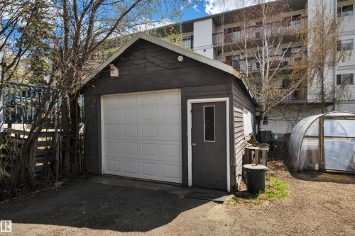 Detached garage featuring a paneled overhead door, a separate pedestrian entry, and horizontal siding - 4907 48 Avenue, Leduc, AB - Outdoor With Exterior