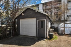 Detached garage featuring a paneled overhead door, a separate pedestrian entry, and horizontal siding - 