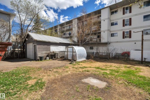 Detached garage with a roll-up door and horizontal wood siding - 4907 48 Avenue, Leduc, AB - Outdoor