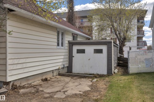 Exterior featuring horizontal siding, a side-facing window, and a separate storage structure with a garage door - 4907 48 Avenue, Leduc, AB - Outdoor With Exterior