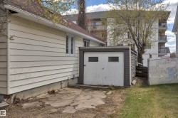 Exterior featuring horizontal siding, a side-facing window, and a separate storage structure with a garage door - 