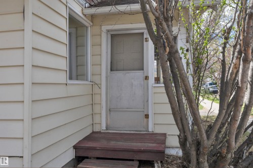 Exterior entry featuring a white screen door and a wooden stoop - 4907 48 Avenue, Leduc, AB - Outdoor