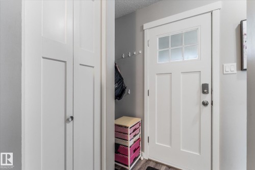 Entryway featuring a white paneled door with frosted glass inserts, brushed nickel door hardware, and wood-finish flooring - 35 Mcleod Place, Edmonton, AB - Indoor Photo Showing Other Room
