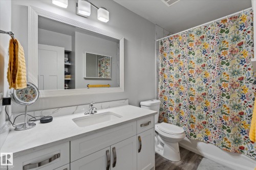 Bathroom featuring a white vanity with an integrated sink, polished chrome faucet, and a quartz countertop with a matching backsplash - 35 Mcleod Place, Edmonton, AB - Indoor Photo Showing Bathroom