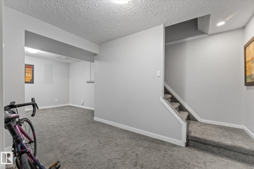 Carpeted lower level featuring light gray walls, white baseboards, a recessed ceiling light, and a carpeted staircase with white trim - 35 Mcleod Place, Edmonton, AB - Indoor Photo Showing Other Room