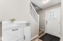 Entryway featuring a white paneled door with glass inserts, wood-finish flooring, a carpeted staircase with white railings, and neutral wall paint - 35 Mcleod Place, Edmonton, AB  - Indoor Photo Showing Other Room 