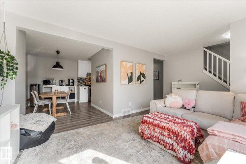 Open-concept living area featuring light gray wall tones and wood-finish flooring - 35 Mcleod Place, Edmonton, AB - Indoor