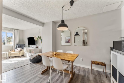 Dining area featuring a wood-finish table, pendant lighting, and two arched wall mirrors - 35 Mcleod Place, Edmonton, AB - Indoor Photo Showing Dining Room