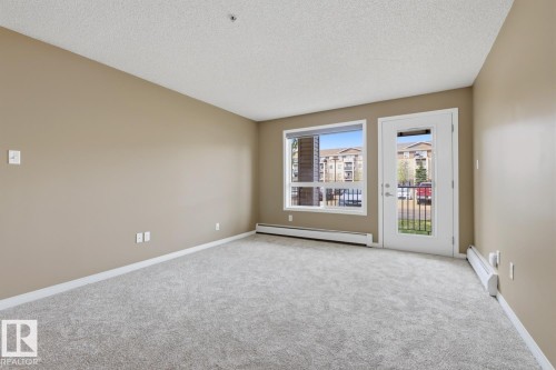 Spacious room featuring light-toned carpet flooring, neutral painted walls, and white baseboards - 5106 7335 South Terwillegar Drive, Edmonton, AB - Indoor Photo Showing Other Room