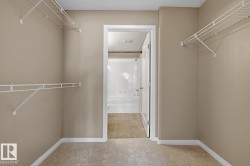 Carpeted interior space with neutral wall paint and white wire shelving - 