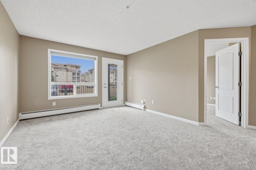 Spacious room featuring light-colored carpeting, neutral wall tones, and white baseboards - 5106 7335 South Terwillegar Drive, Edmonton, AB - Indoor Photo Showing Other Room