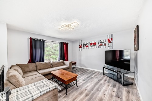 Living area featuring wood-finish flooring, light grey walls, and a recessed window - 3802 52 Street, Wetaskiwin, AB 
