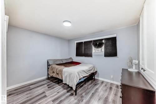 Room featuring wood-finish flooring, light grey painted walls, and a window with dark blinds - 3802 52 Street, Wetaskiwin, AB 