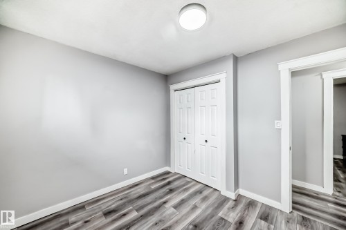 Room featuring light gray walls, wood-finish flooring, and white trim - 3802 52 Street, Wetaskiwin, AB 
