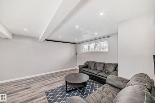 Spacious room featuring wood-finish flooring, recessed lighting, a window, and light gray painted walls - 3802 52 Street, Wetaskiwin, AB 
