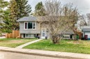 Split-level residence featuring gray horizontal siding, a gabled roofline, and mature front yard landscaping - 3802 52 Street, Wetaskiwin, AB 