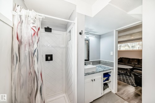 Compact shower enclosure featuring a textured white surround and black fixtures - 3802 52 Street, Wetaskiwin, AB 
