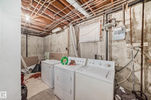 Basement utility area featuring exposed wood joists, concrete walls, and a window with blinds - 3802 52 Street, Wetaskiwin, AB 